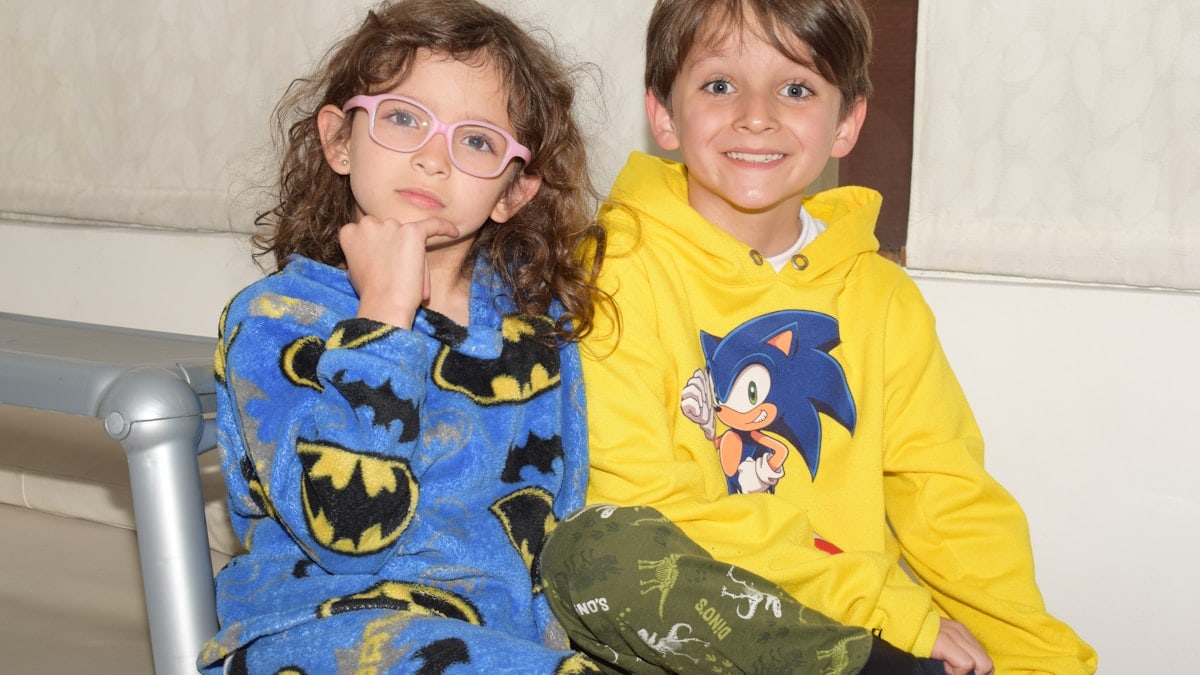 A couple of kids sitting next to each other